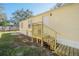 Rear view of a mobile home with wooden steps and a small patio at 9532 Lake Dr, New Port Richey, FL 34654