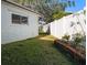 Landscaped side yard with lush grass and flower bed at 12352 Monarch Cir, Seminole, FL 33772