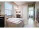 Spa-like bathroom with a large soaking tub and view into bedroom at 13423 White Sapphire Rd, Riverview, FL 33579