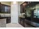 Modern kitchen with dark cabinetry, granite countertops, and stainless steel appliances at 13423 White Sapphire Rd, Riverview, FL 33579