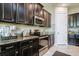 Modern kitchen with dark cabinetry, granite countertops, and stainless steel appliances at 13423 White Sapphire Rd, Riverview, FL 33579