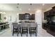 Modern kitchen with island and seating, dark cabinetry, and granite countertops at 13423 White Sapphire Rd, Riverview, FL 33579