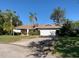 Single-story home with attached garage, landscaping, and palm trees at 13981 103Rd Ave, Largo, FL 33774