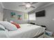 Bright bedroom with a comfortable bed, ceiling fan, and coastal-themed decor at 1600 Beach Trl, Indian Rocks Beach, FL 33785