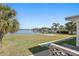 Peaceful waterfront view with lush lawn and palm trees at 17163 2Nd E St, North Redington Beach, FL 33708