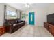 Living room featuring tile floors, a ceiling fan, and a brown leather sofa at 1840 42Nd N Ave, St Petersburg, FL 33714