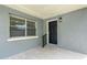 Front porch with black door and gray stucco walls at 2716 W Heiter St, Tampa, FL 33607