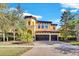 Two-story house with a two-car garage, brick driveway, and lush landscaping at 2847 Calvano Dr, Land O Lakes, FL 34639