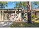 Front view of a condo showing a garage and well-manicured landscaping at 2902 Oak Cir, Tarpon Springs, FL 34689