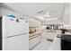 Galley-style kitchen with white cabinets and a view into the living area at 2902 Oak Cir, Tarpon Springs, FL 34689