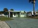 Front view of a charming light green manufactured home with a spacious driveway at 35127 Danny Dr, Zephyrhills, FL 33541