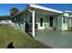 Light green mobile home with covered patio, located on a canal at 35127 Danny Dr, Zephyrhills, FL 33541