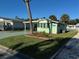 Side view of a light green manufactured home showcasing a well-maintained lawn at 35127 Danny Dr, Zephyrhills, FL 33541