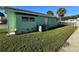 Side view of light green mobile home next to a canal at 35127 Danny Dr, Zephyrhills, FL 33541