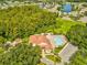 Community pool and clubhouse, surrounded by lush trees at 4420 Northampton Dr, New Port Richey, FL 34653