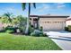 Tan one-story house with a two-car garage and well-manicured lawn at 5806 Hidden Falls Ln, Apollo Beach, FL 33572