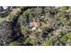 Aerial view of a home with pool, nestled on a wooded lot near the water at 7106 Riverwood Blvd, Tampa, FL 33615