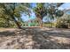 Single story teal home with carport, surrounded by lush landscaping at 7106 Riverwood Blvd, Tampa, FL 33615