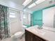 Bathroom with teal walls, walk-in shower, and a vanity with a granite countertop at 8015 Idlebriar Ln, Port Richey, FL 34668