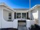 Front view of a single story home with a white exterior and dark windows at 8015 Idle Briar Ln, Port Richey, FL 34668