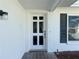 Front entryway with a white door and dark shutters at 8015 Idlebriar Ln, Port Richey, FL 34668