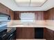 Kitchen with wood cabinets, a double sink, and a window at 8015 Idlebriar Ln, Port Richey, FL 34668