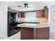 A galley kitchen with dark wood cabinets, black appliances, and a breakfast bar at 8015 Idlebriar Ln, Port Richey, FL 34668