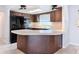 A galley kitchen with dark wood cabinets, black appliances, and a breakfast bar at 8015 Idlebriar Ln, Port Richey, FL 34668