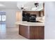 A galley kitchen with dark wood cabinets, black appliances, and a breakfast bar at 8015 Idlebriar Ln, Port Richey, FL 34668