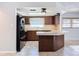 Kitchen boasts wood cabinets, black appliances, and a breakfast bar at 8015 Idlebriar Ln, Port Richey, FL 34668