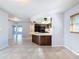 A galley kitchen with dark wood cabinets, black appliances, and a breakfast bar at 8015 Idlebriar Ln, Port Richey, FL 34668