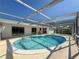 Relaxing kidney-shaped pool with screened enclosure at 8015 Idle Briar Ln, Port Richey, FL 34668