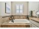 Relaxing bathroom with a large soaking tub, tile surround, and window at 8144 Sequester Loop, Land O Lakes, FL 34637