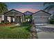 Attractive one-story home with stone accents and a two-car garage at dusk at 8144 Sequester Loop, Land O Lakes, FL 34637