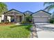 One-story home with stone accents, two-car garage, and well-manicured lawn at 8144 Sequester Loop, Land O Lakes, FL 34637