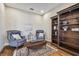 Cozy sitting area with hardwood floors, armchairs, and a large bookcase at 8144 Sequester Loop, Land O Lakes, FL 34637