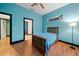 Light teal bedroom with wood flooring and window at 8356 Owls Roost Ln, Brooksville, FL 34601