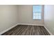 Simple bedroom with wood-look floors and a window with blinds at 9060 Moonlit Meadows Loop, Riverview, FL 33578