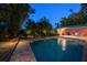 Inviting pool area with brick patio and lush landscaping at dusk at 1020 Marine St, Clearwater, FL 33755