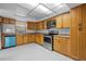 Efficient kitchen with wood cabinets, tile flooring, and stainless steel appliances at 1321 Riverside Dr, Tarpon Springs, FL 34689
