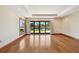 Bright bedroom with hardwood floors, tray ceiling, window, and sliding glass doors to lanai overlooking waterfront at 1997 Kansas Ne Ave, St Petersburg, FL 33703