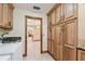 Open laundry room with wood cabinets and view into the living room at 1997 Kansas Ne Ave, St Petersburg, FL 33703