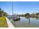 Waterfront view featuring a boat dock, lush landscaping, and a boat in the canal at 1997 Kansas Ne Ave, St Petersburg, FL 33703