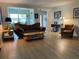 Cozy living room featuring hardwood floors, modern furniture, and an open floor plan to the dining area at 209 Westwinds Dr, Palm Harbor, FL 34683