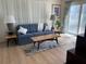 Living room with light hardwood floors, slider door and neutral colored walls at 209 Westwinds Dr, Palm Harbor, FL 34683
