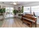 Bright sunlit room with a piano, access to a patio and plenty of plants at 209 Westwinds Dr, Palm Harbor, FL 34683