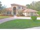 Two story house with circular driveway and lush landscaping at 3050 Wentworth Way, Tarpon Springs, FL 34688