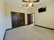 Spacious bedroom with carpeted floors, ceiling fan, and double doors at 3050 Wentworth Way, Tarpon Springs, FL 34688