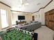 Bonus room featuring foosball table, gray sofa, and carpeted floor at 3050 Wentworth Way, Tarpon Springs, FL 34688