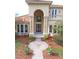 Two-story house with tile roof, arched entry, and landscaped yard at 3050 Wentworth Way, Tarpon Springs, FL 34688